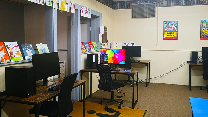 computers and monitors setting on desks in the library